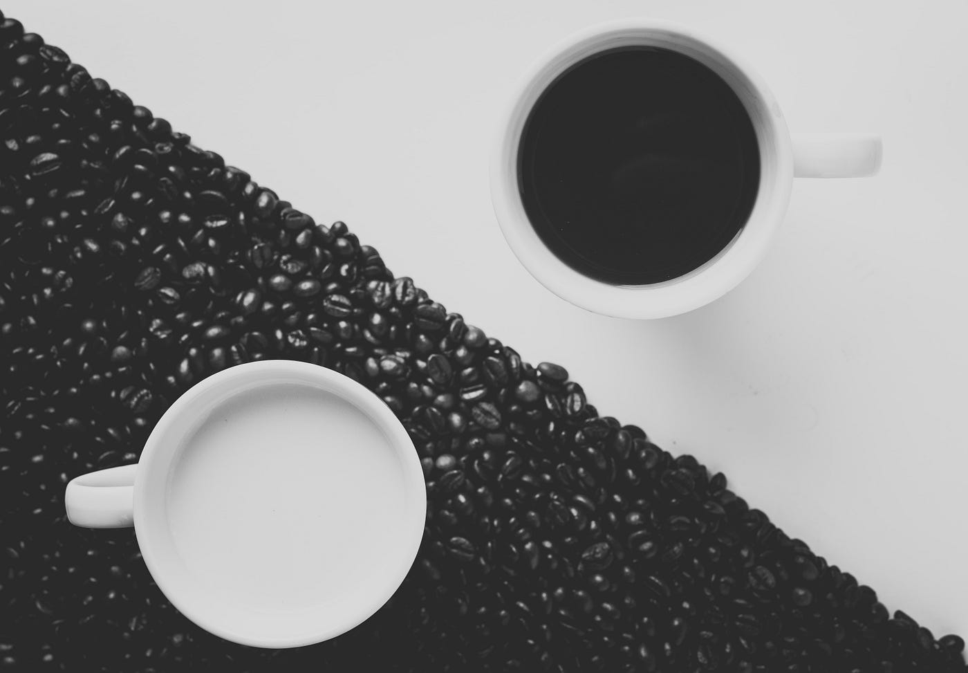 A coffee cup with white liquid and a coffee cup with dark liquid on contrasting backgrounds